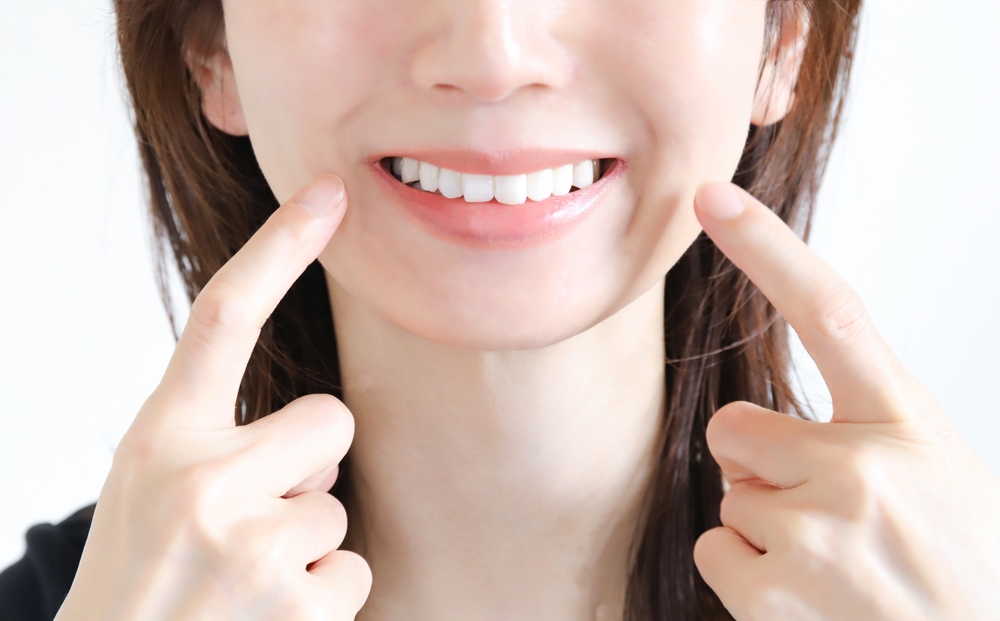 白い歯を見せて笑う女性